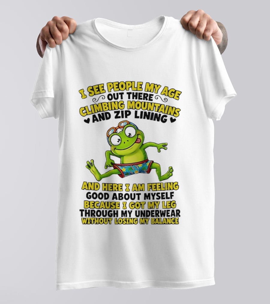 I See People My Age Climbing Mountains And Zip Lining Cartoon Frog Feeling Good Without Losing Balance T-Shirt