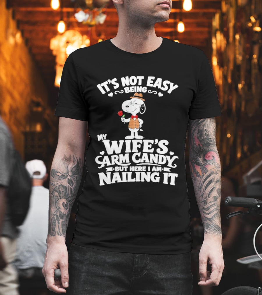 Snoopy It's Not Easy Being My Wife's Arm Candy But Here I Am Nailing It T-Shirt
